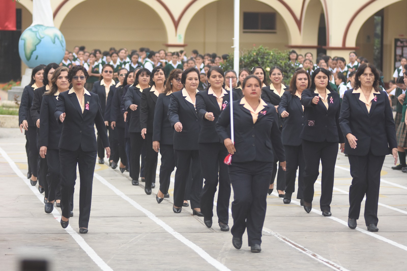 Personal del colegio participando en el desfile