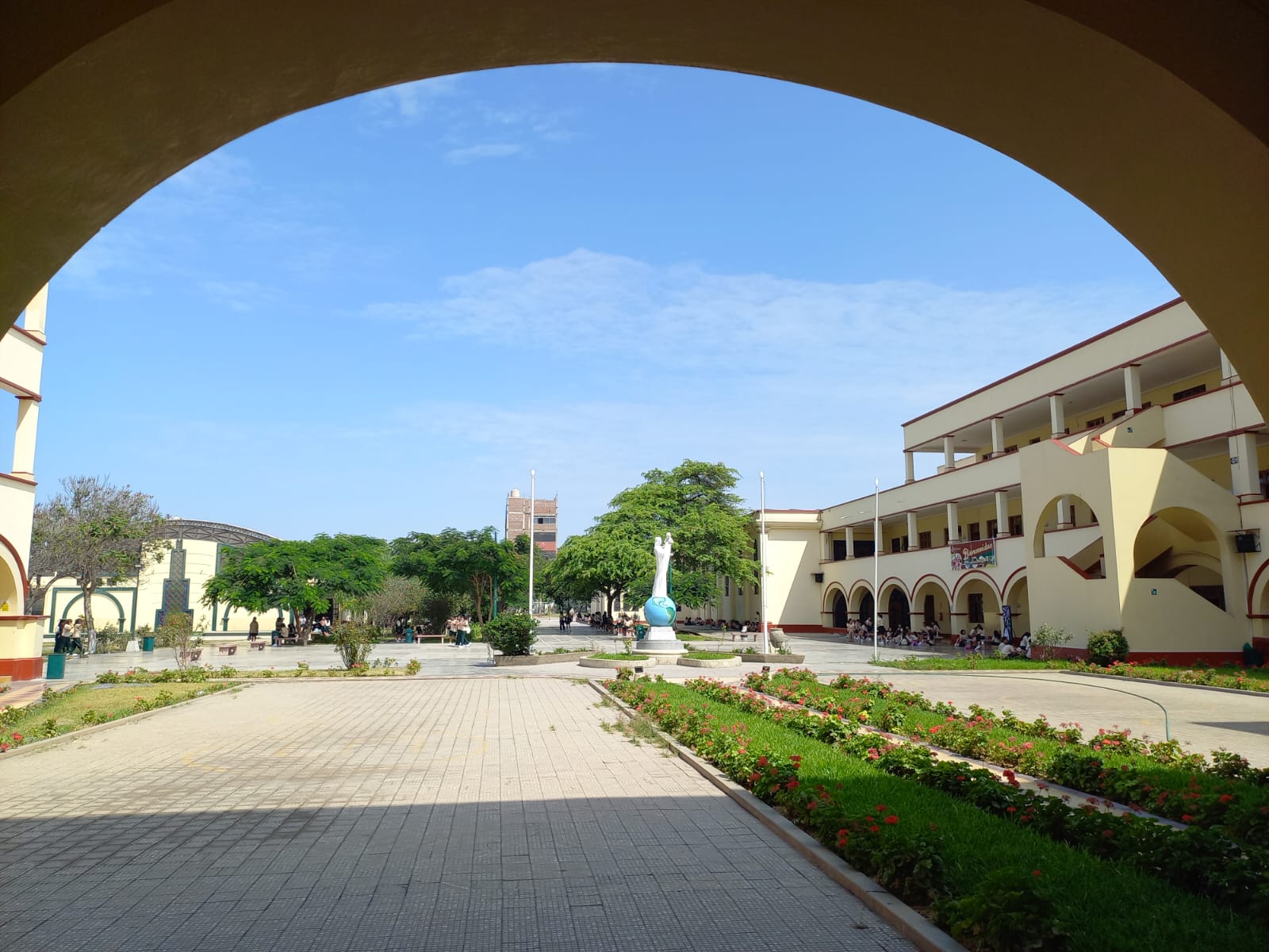 Patio y jardines del colegio vistos desde un arco